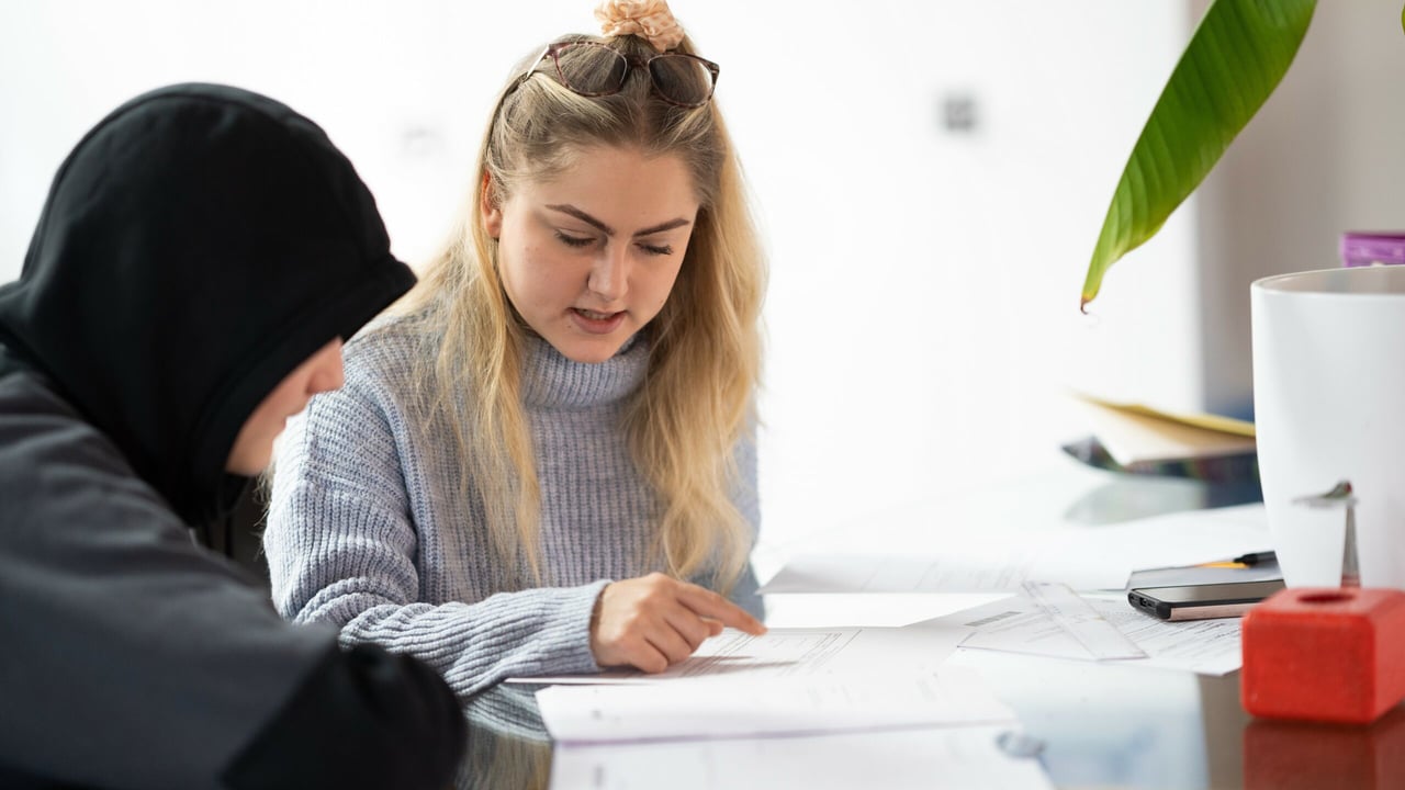 Child working through 11 Plus preparation materials with a tutor